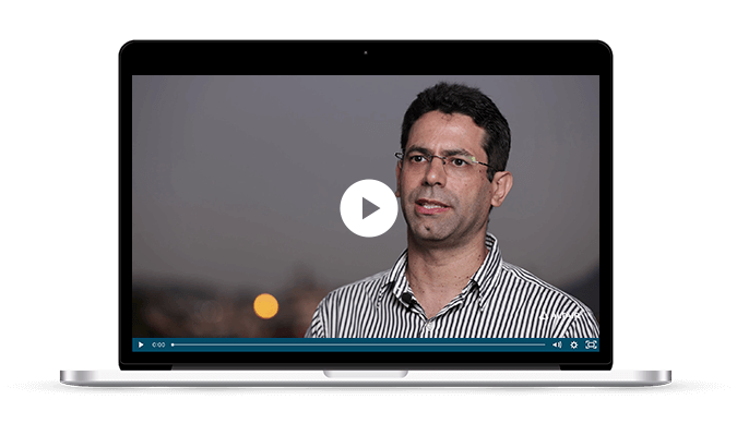 Laptop monitor with play-button on headshot of man speaking; play-button starts video about Altair SimSolid solutions for renewable energy.