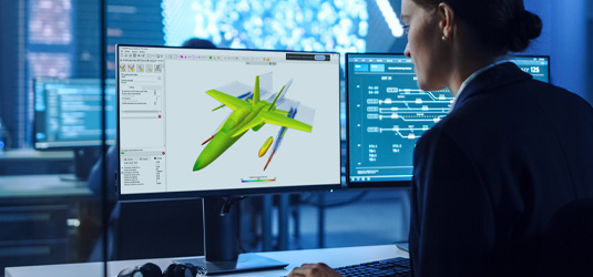 Woman at monitor shows digital engineering defense solution for sustainment and modernization on a jet used for ISR missions.