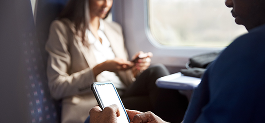 Travelers on a passenger train utilizing connected devices.