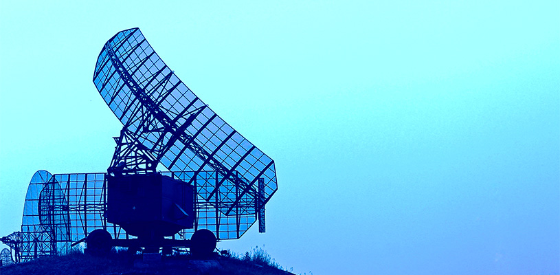 Mobile military radar station for radar spectrum monitoring, surveillance and defense communication, against a blue sky.