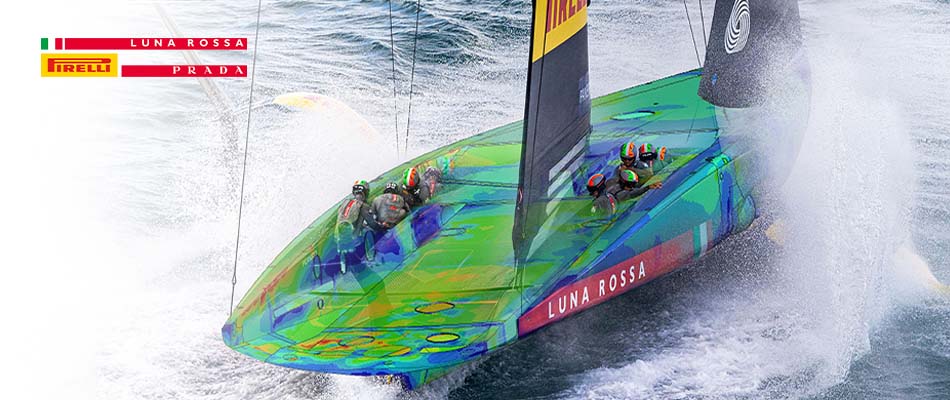 A photograph of a Luna Rossa Prada Pirelli sailboat on choppy, open water. The team's official logo is displayed in the corner.