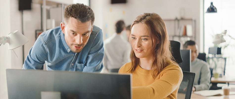 A senior data scientist shows a new employee how to build and deploy a generative AI module that will be part of a large data analytics development project.