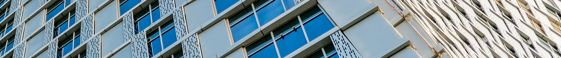 A concrete building featuring numerous windows on its facade, showcasing modern architectural design.