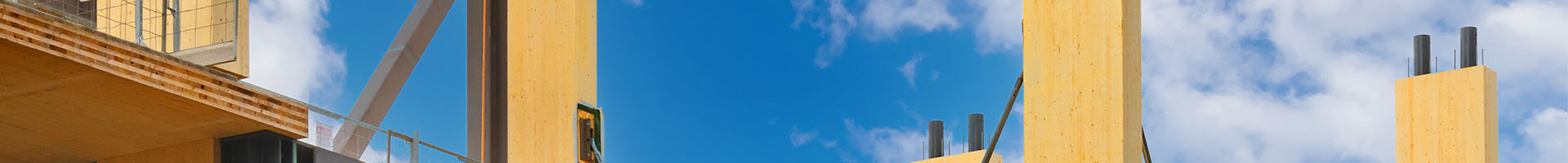 A construction site of a large building with visible wooden beams, emphasizing its structural timber architecture.