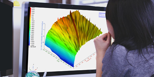 Engineer observing a waterfall diagram of gearbox acoustic results from OptiStruct via Altair HyperGraph on a computer monitor.